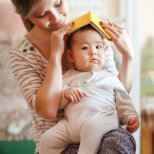 mother playing with books with her baby